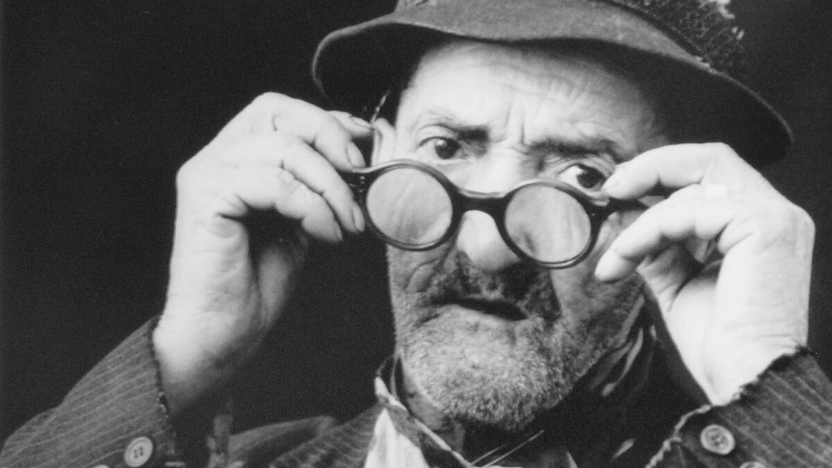 Un vecchio con gli occhiali tondi in mano: particolare di una delle foto in mostra di Michele Pellegrino