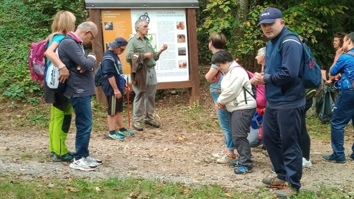 Fotografia: Un momento della visita con il guardiaparco davanti ad un pannello dell'archeoparco didattico La Roccarina