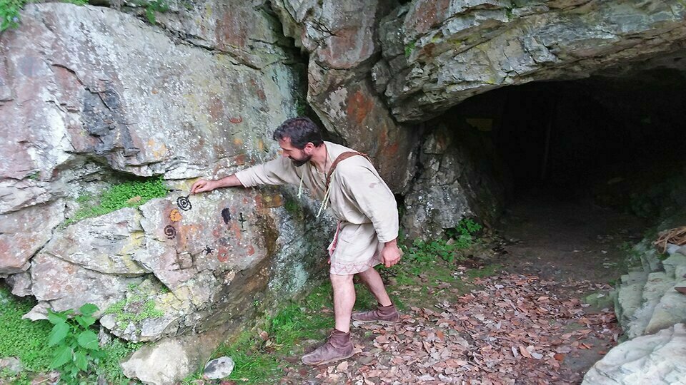 Nella fotografia: un archeologo davanti all'ingresso delle grotte durante l'animazione di Storie di uomini e orsi