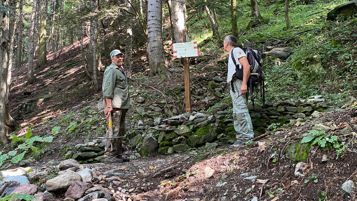 Nella foto: un operaio e un guardiaparco presso il cartello segnaletico sull'itinerario per il rifugio Garelli (H1) che indica il nuovo sentiero che conduce al Saut.