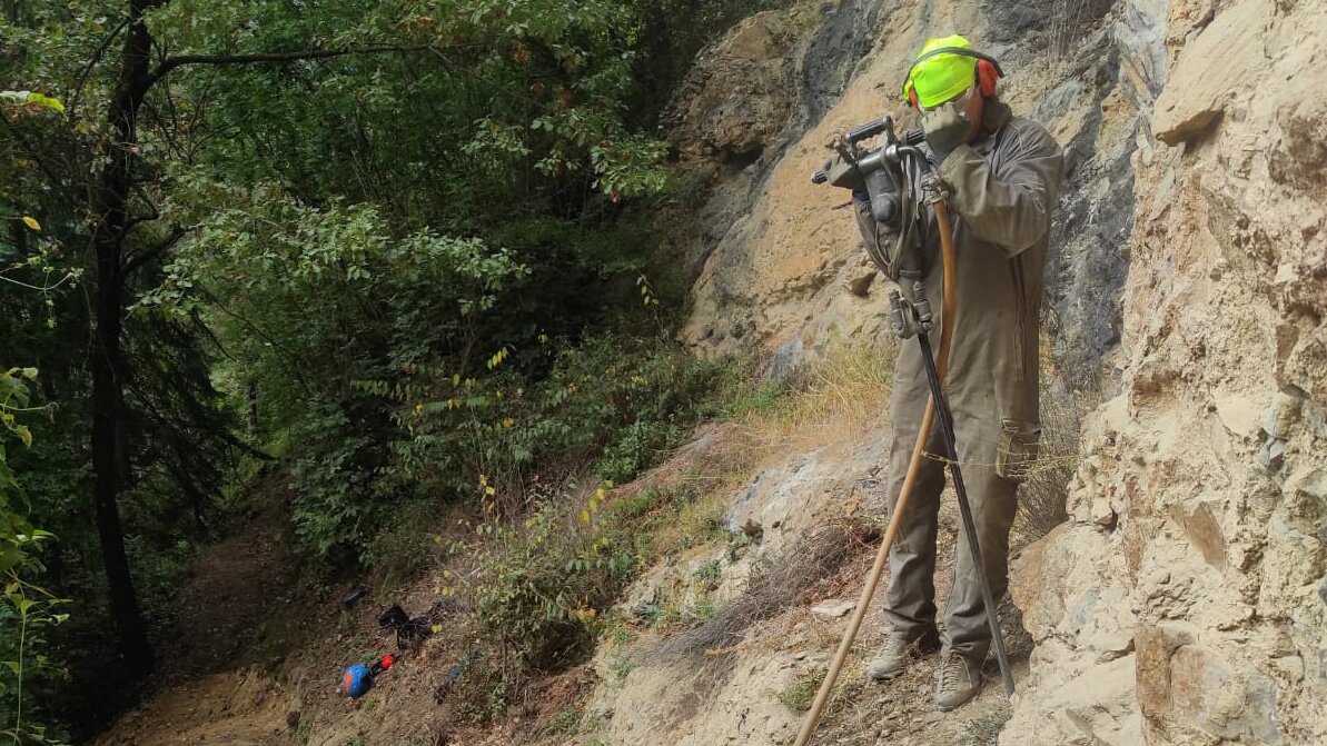 Nella fotografia: un addetto di GrandAlpi con il martello pneumatico in azione per la manutenzione del sentiero delle Grotte | GrandAlpi.