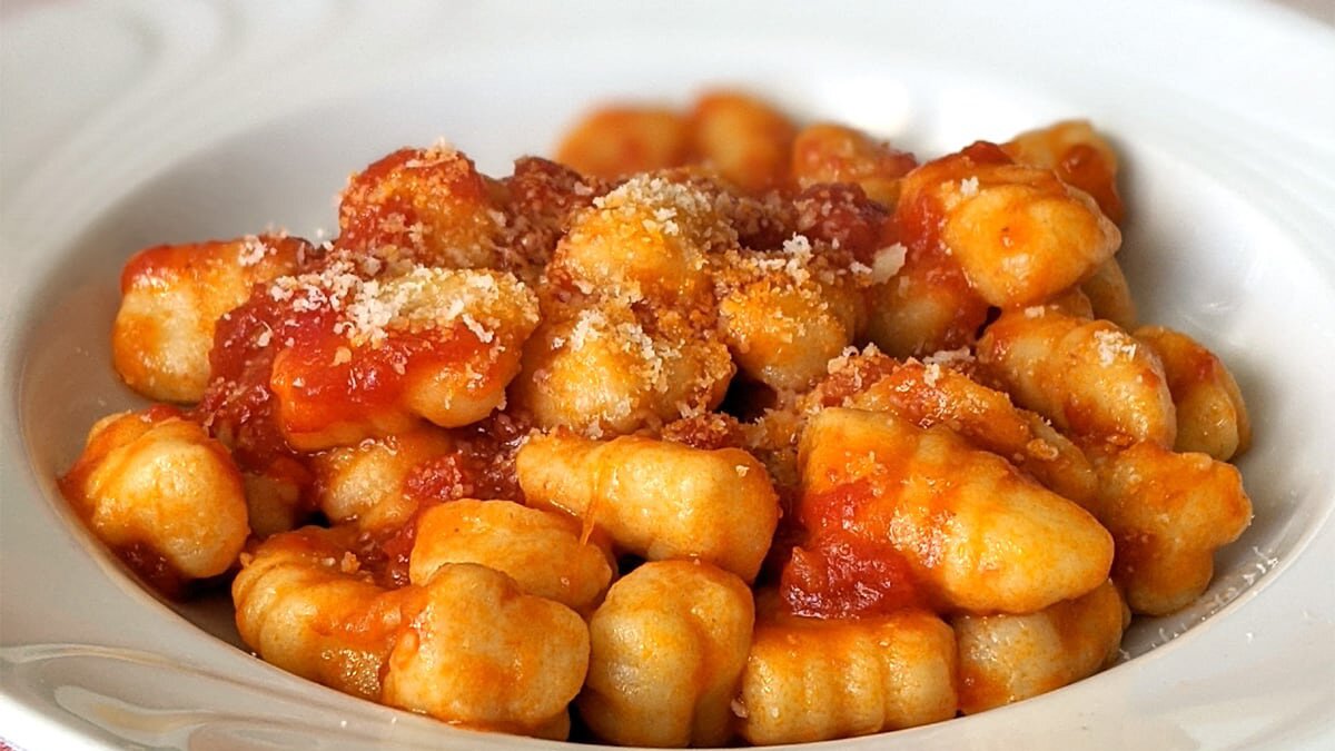 Nella foto: un piatto di gnocchi conditi con sugo rosso e formaggio