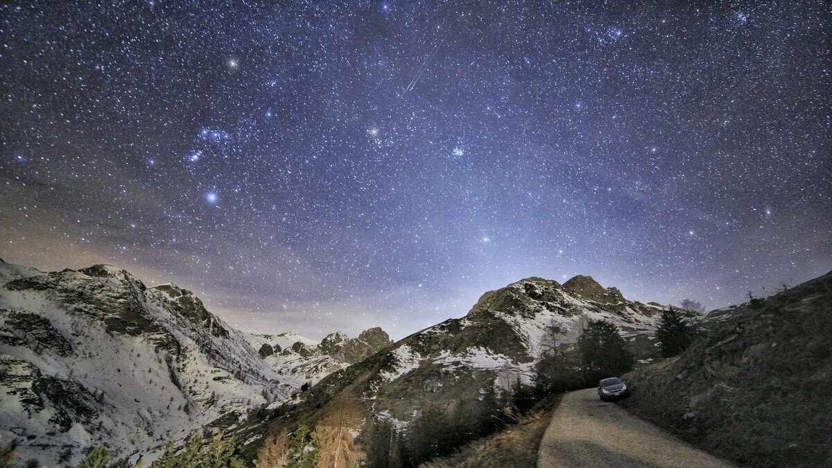 La foto di P. Demaria mostra il cielo stellato in alto, sotto le montagne. E' stata scattata in Val Grana. Fine della descrizione.