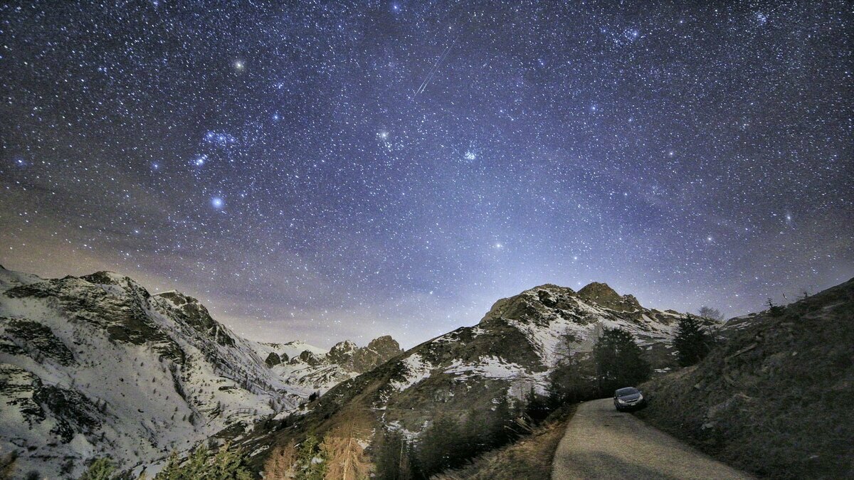 Lo scatto di P. Demaria mostra il cielo stellato sopra la Val Grana. In basso le montagne. Fine della descrizione.