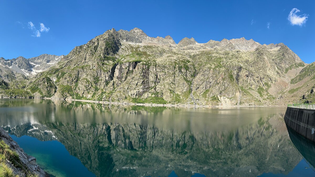 Nella foto: il versante orientale dell'Argentera dalle sponde del lago artificiale Chiotas. Si vedono anche il lago e a destra il coronamento della diga| G. Bernardi. Fine descrizione fotografia.