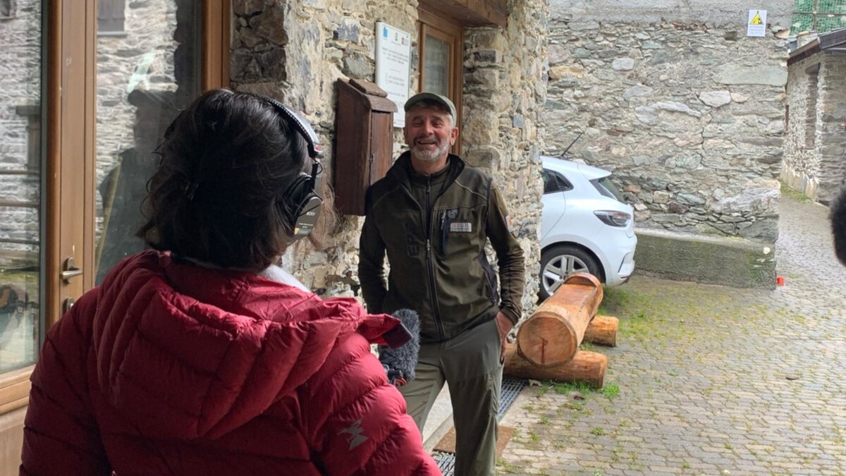 Lo scatto di C. Luconi mostra il guardiaparco M. Sciandra impegnato nell'intervista realizzata per il video relativo all'Associazione Fondiaria Carnino. A sinistra, di spalle, l'operatore e il microfono per registrare l'intervista. Fine della descrizione.