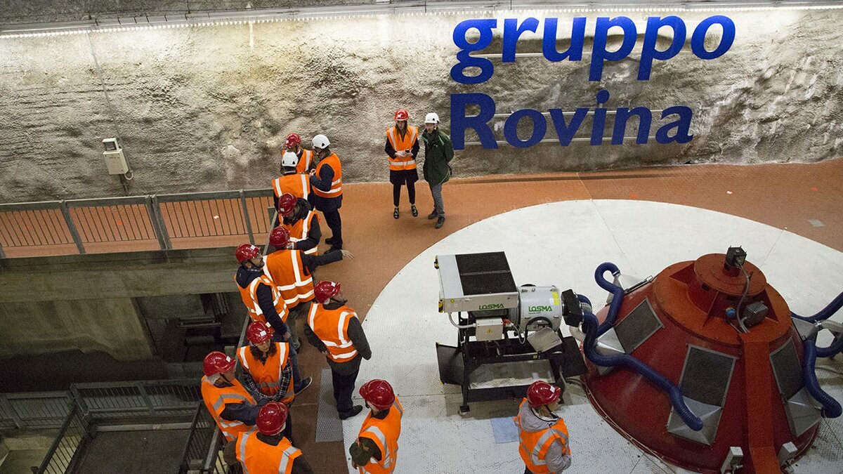 Nella foto si vedono dei visitatori nella centrale dall'alto. Fine descrizione foto.