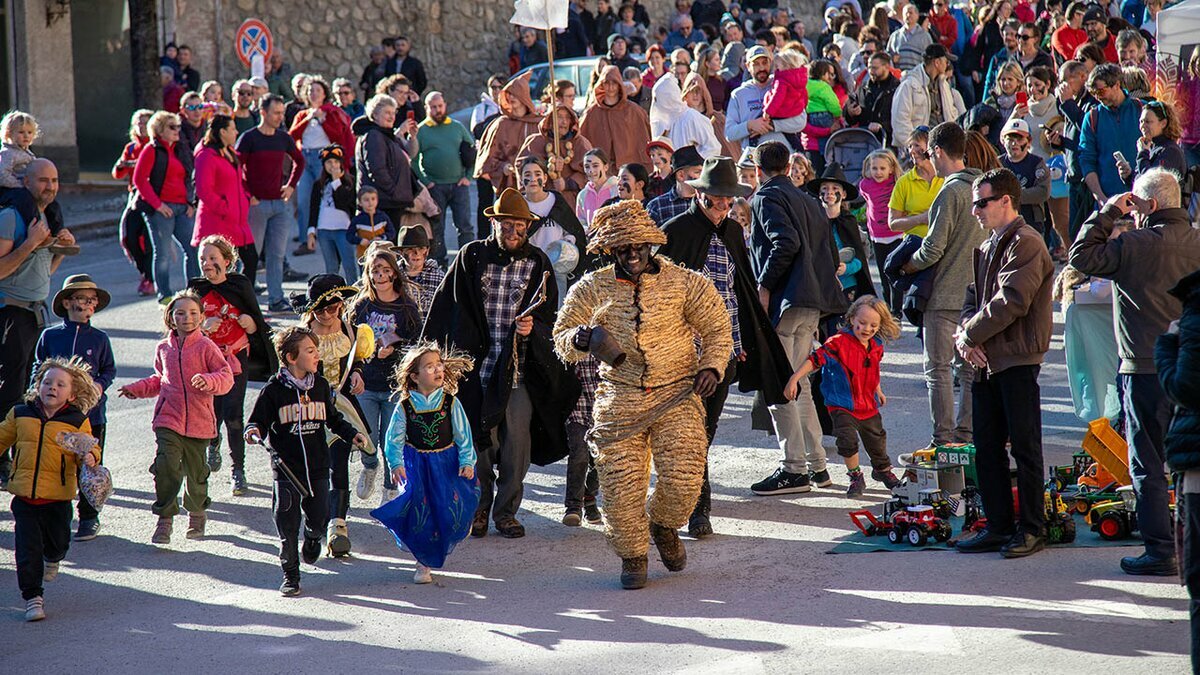 L'Orso di Segale fugge da Domatori e Fra durante il Carnevale alpino di Valdieri. Autore: Francesca Parracone. Fine descrizione dell'immagine.