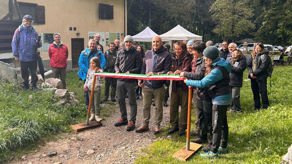 Lo scatto di E. Chiecchio mostra il taglio del nastro per inaugurare il Cammino del bosco. In foto si vedono il diretto APAM L. Gautero, il Presidente A. Erbì, I. Borgna e le Guide del gruppo Clorofilla. Fine descrizione foto.